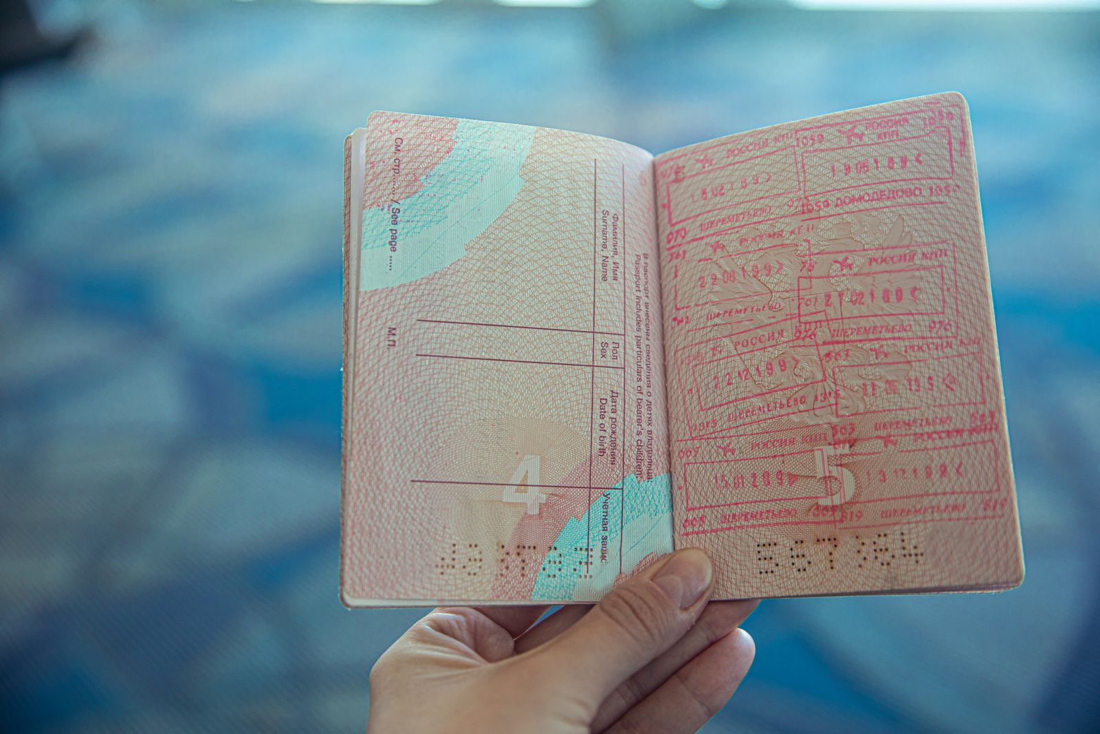 Traveler holding open a passport full of entry stamps, as needed on cruises for non-US citizens